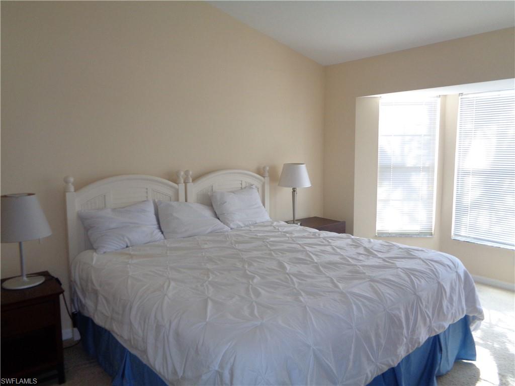 6115 Reserve Circle, Unit 2004 Naples, FL 34119 - Photo 10 of 10 a large bed sitting in a bedroom next to a window