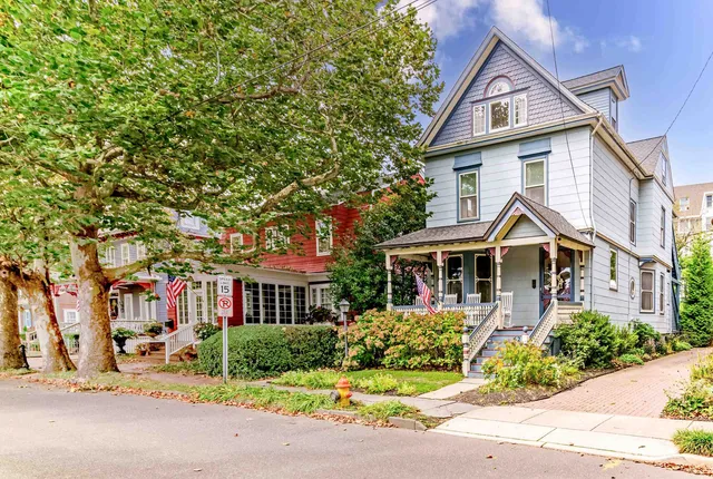a front view of a house with a yard and potted plants