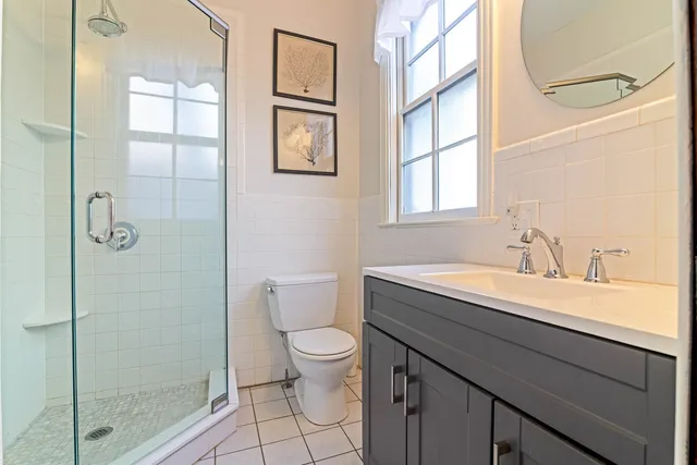a bathroom with a granite countertop sink a toilet and shower