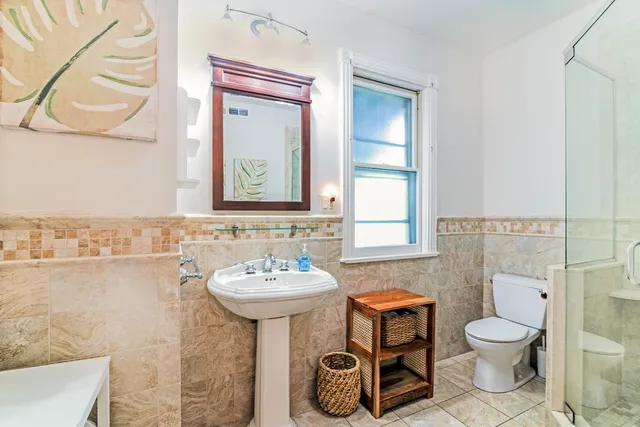 a bathroom with a toilet sink and mirror