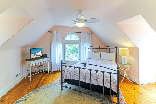 a living room with a bed furniture and a wooden floor