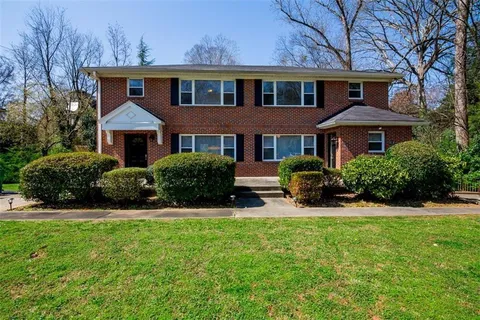 a front view of a house with yard and green space