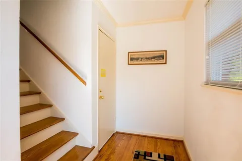 a view of a hallway with wooden floor and entryway