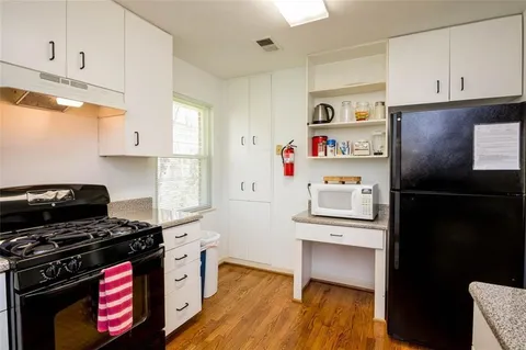 a kitchen with a refrigerator and a stove top oven