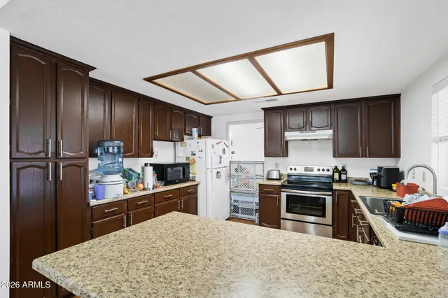 a kitchen with stainless steel appliances granite countertop a sink stove and refrigerator
