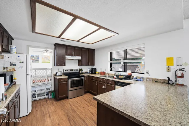a kitchen with stainless steel appliances granite countertop sink stove top oven and cabinets