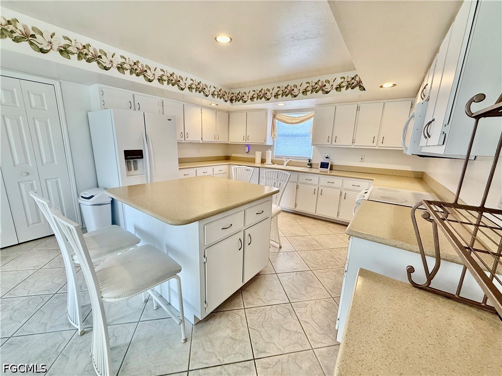 1400 Graham Circle Lehigh Acres, FL 33936 - Photo 20 of 47 a kitchen with cabinets and chairs