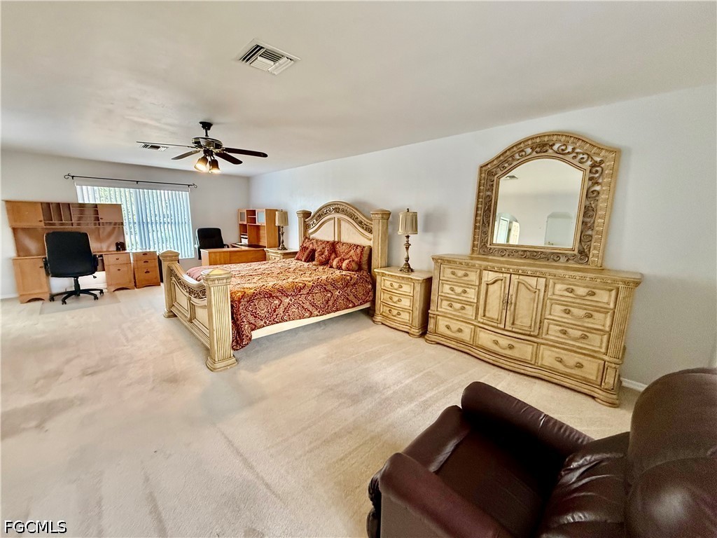 1400 Graham Circle Lehigh Acres, FL 33936 - Photo 33 of 47 a spacious bedroom with a bed a couch and dresser