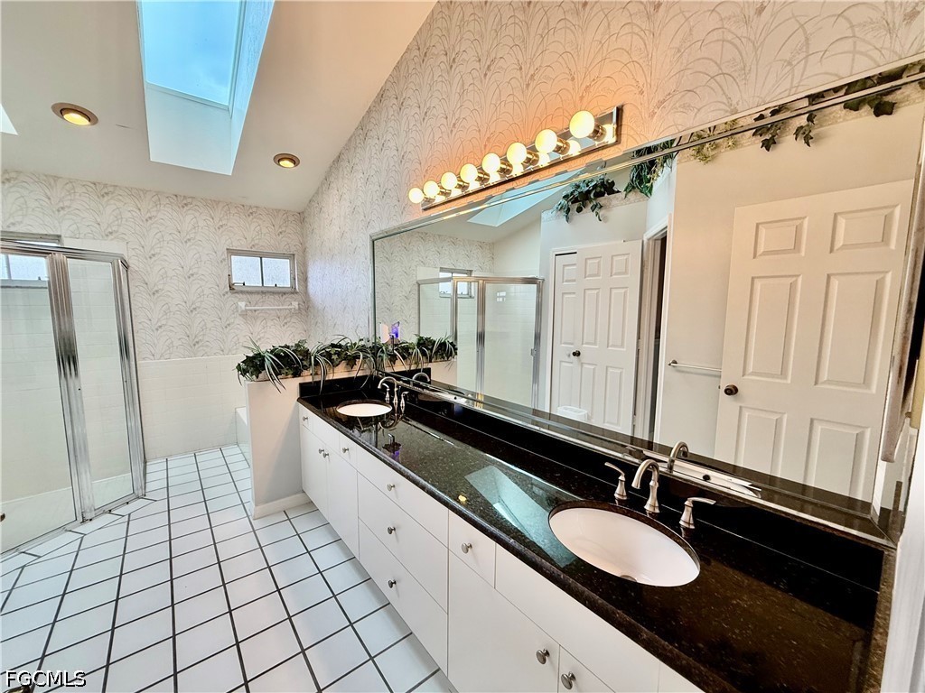 1400 Graham Circle Lehigh Acres, FL 33936 - Photo 34 of 47 a spacious bathroom with a double vanity sink a mirror and a shower