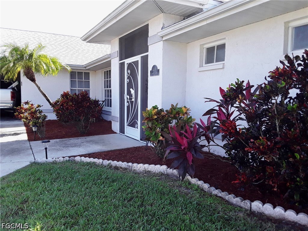 1400 Graham Circle Lehigh Acres, FL 33936 - Photo 45 of 47 a view of a house with a yard and a garden