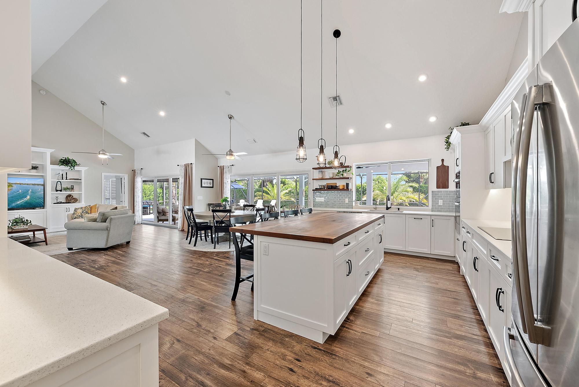 11 Loggerhead Lane Tequesta, FL 33469 - Photo 11 of 46 a kitchen with stainless steel appliances kitchen island granite countertop a large center island attached withe living room