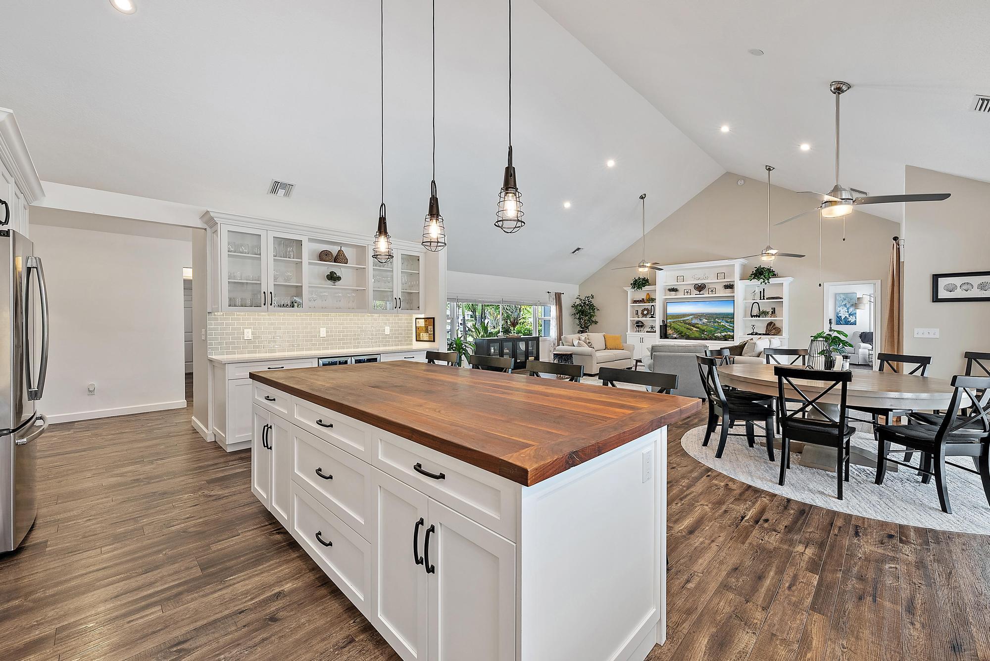 11 Loggerhead Lane Tequesta, FL 33469 - Photo 13 of 46 a kitchen with stainless steel appliances granite countertop a kitchen island a stove and a wooden floors