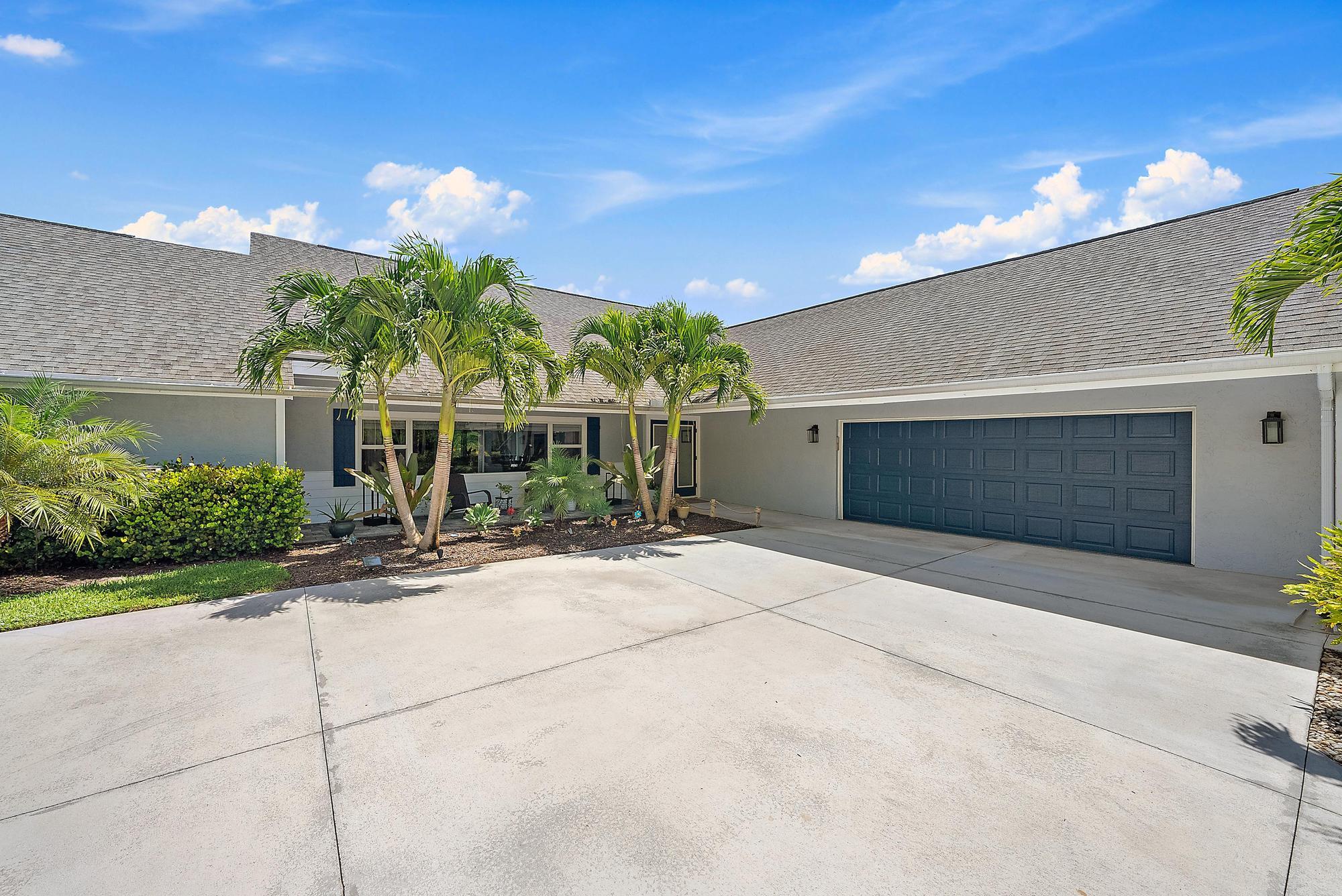 11 Loggerhead Lane Tequesta, FL 33469 - Photo 26 of 46 a front view of a house with yard and a garage
