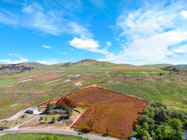 15610 North Beaver Dam Road, Unit 2 Collinston, UT 84306 - Photo 2 of 10 Expansive property featuring a single-story residence with a light-colored roof and a detached garage/storage building