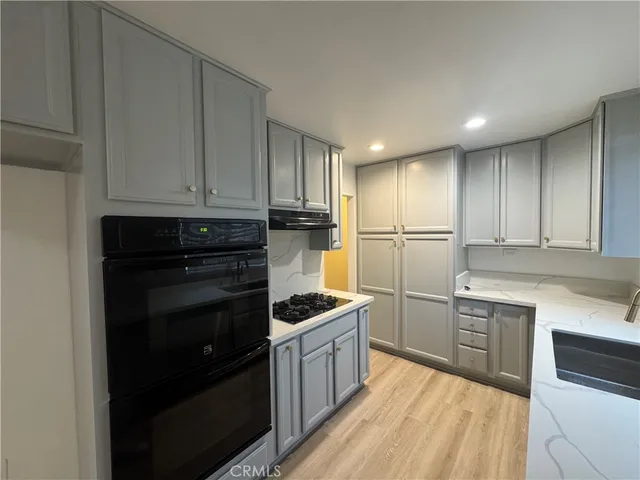 a kitchen with a refrigerator stove top oven and cabinets