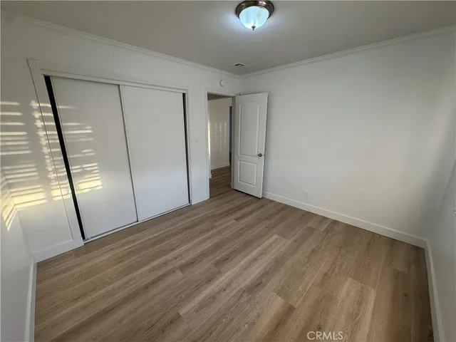 a view of empty room with wooden floor