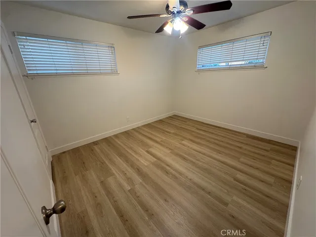 a view of a room with wooden floor and fan
