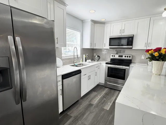 a kitchen with stainless steel appliances a refrigerator sink and microwave