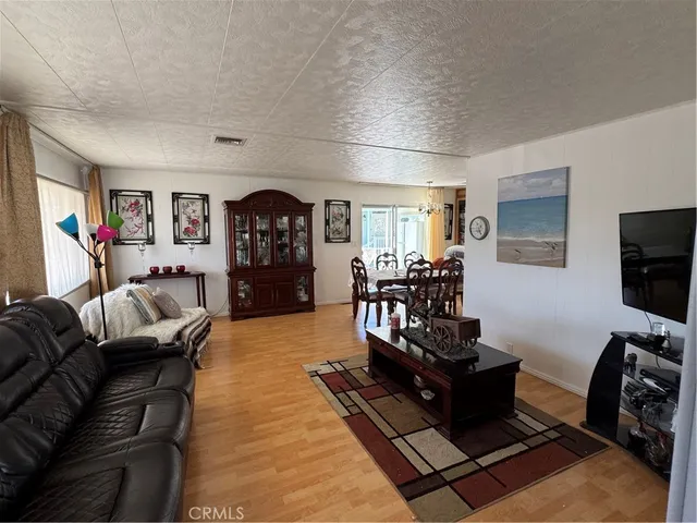 a living room with furniture and a dining table with kitchen view