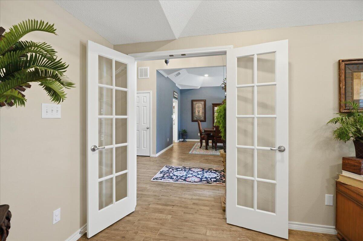 4612 100th Street Lubbock, TX 79424 - Photo 14 of 55 hallway with wooden floor and a potted plant