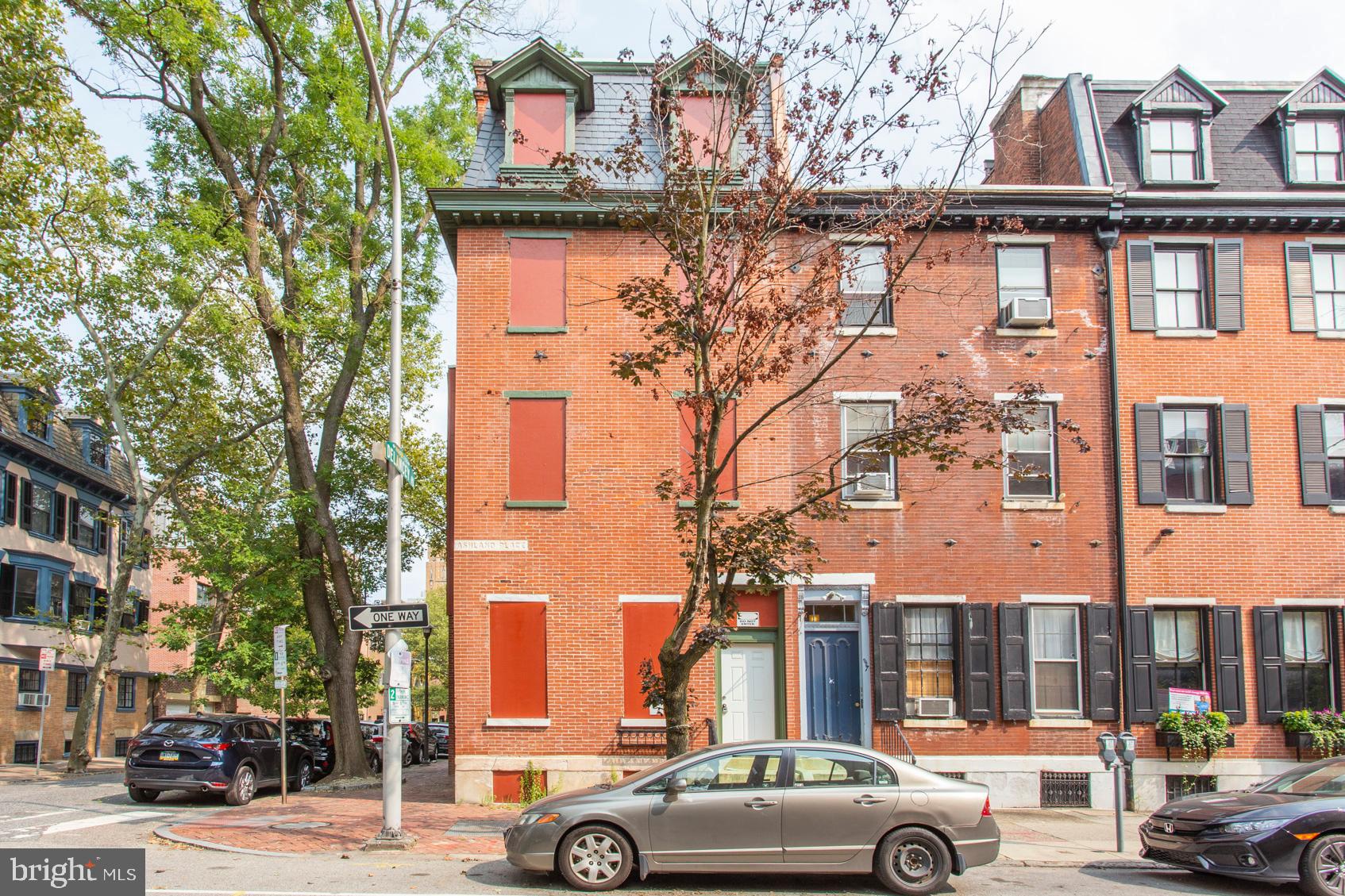 a view of a building and car parked on the road