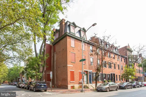 a view of a building and car parked on the roadside