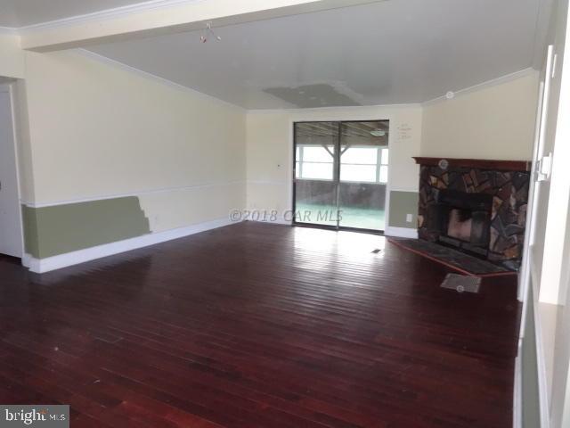 36778-3 3 Bridges Road Willards, MD 21874 - Photo 4 of 18 an empty room with wooden floor fire place and windows