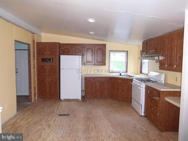 36778-3 3 Bridges Road Willards, MD 21874 - Photo 8 of 18 a kitchen with a sink a counter top space stainless steel appliances and cabinets
