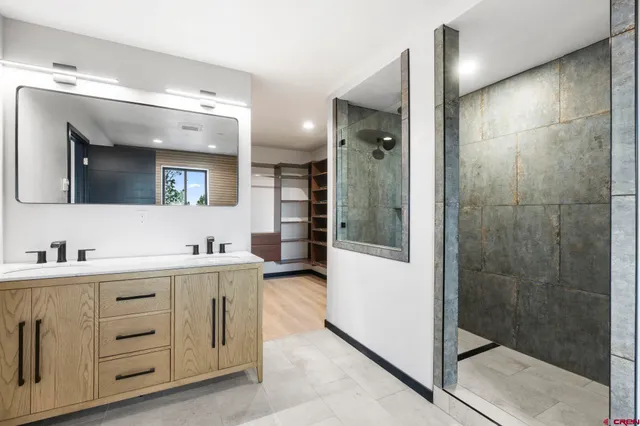 a bathroom with a double vanity sink mirror and shower