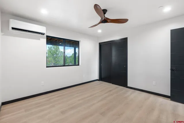 an empty room with a window and a ceiling fan