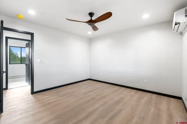 a view of a livingroom with wooden floor and a ceiling fan
