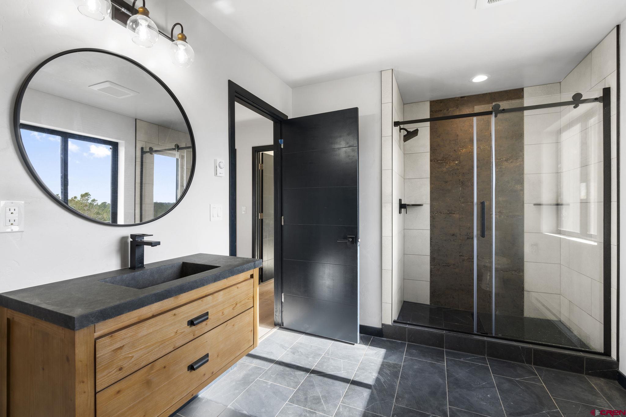 192 Rawhide Road Durango, CO 81303 - Photo 23 of 41 a bathroom with a sink a mirror a vanity and a shower