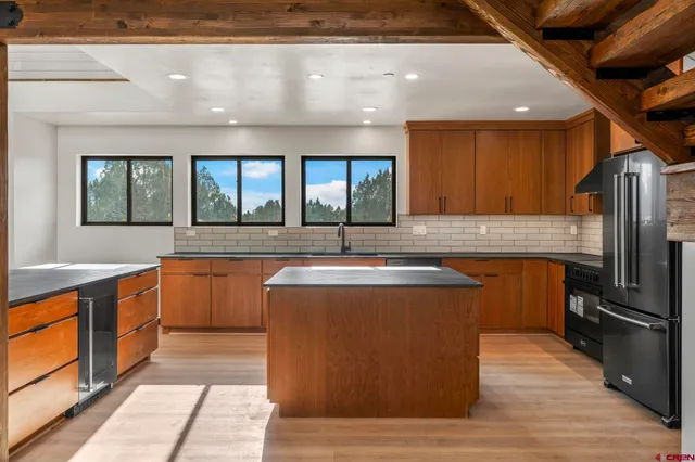 a kitchen with stainless steel appliances granite countertop a sink a stove and a refrigerator