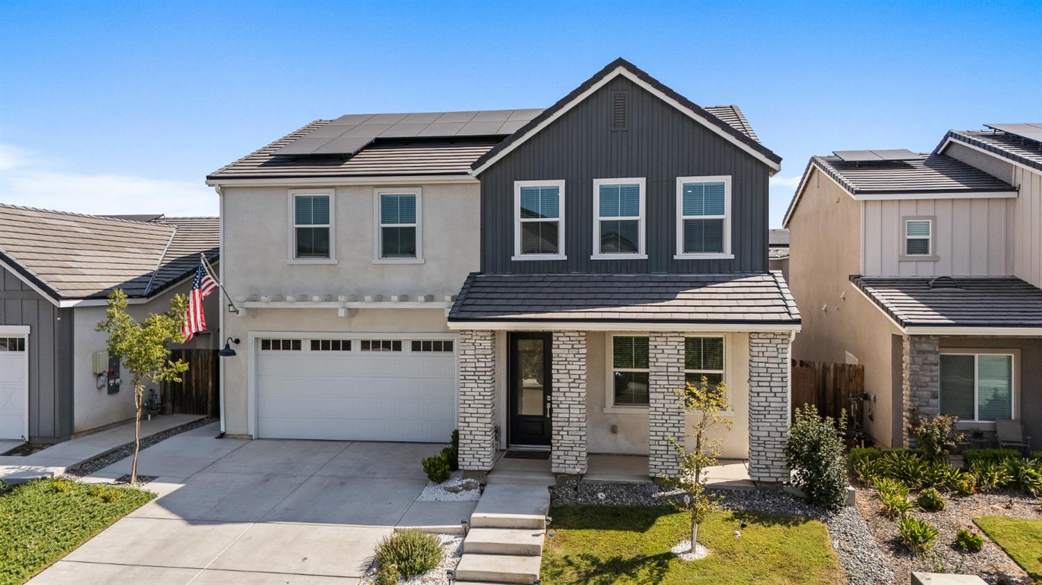 a front view of a house with yard and parking