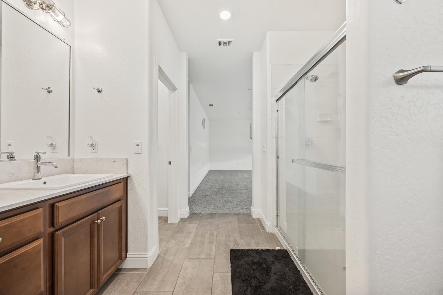 153 Boulder Drive Madera, CA 93636 - Photo 11 of 32 a bathroom with a sink and a mirror
