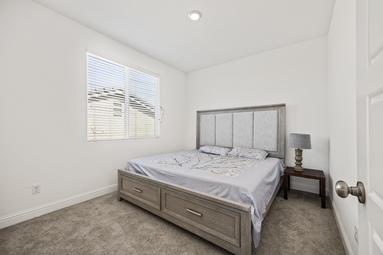 153 Boulder Drive Madera, CA 93636 - Photo 27 of 32 a bed sitting in a bedroom next to a window