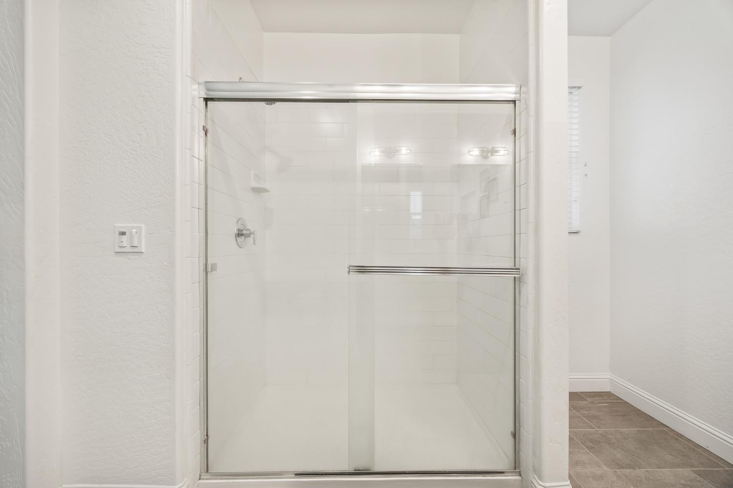 153 Boulder Drive Madera, CA 93636 - Photo 10 of 32 a bathroom with a glass shower door