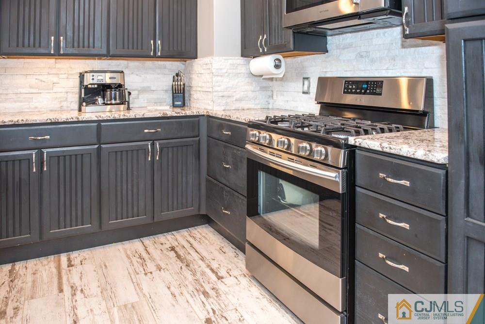 29 Mercer Road Old Bridge, NJ 08857 - Photo 8 of 24 a kitchen with granite countertop wooden cabinets and a stove top oven