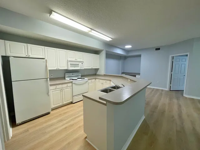 a kitchen with a sink a stove a refrigerator and a refrigerator