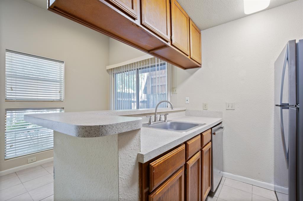 2311 Nueces Street, Unit 101 Austin, TX 78705 - Photo 2 of 6 a kitchen with stainless steel appliances granite countertop a sink and a refrigerator