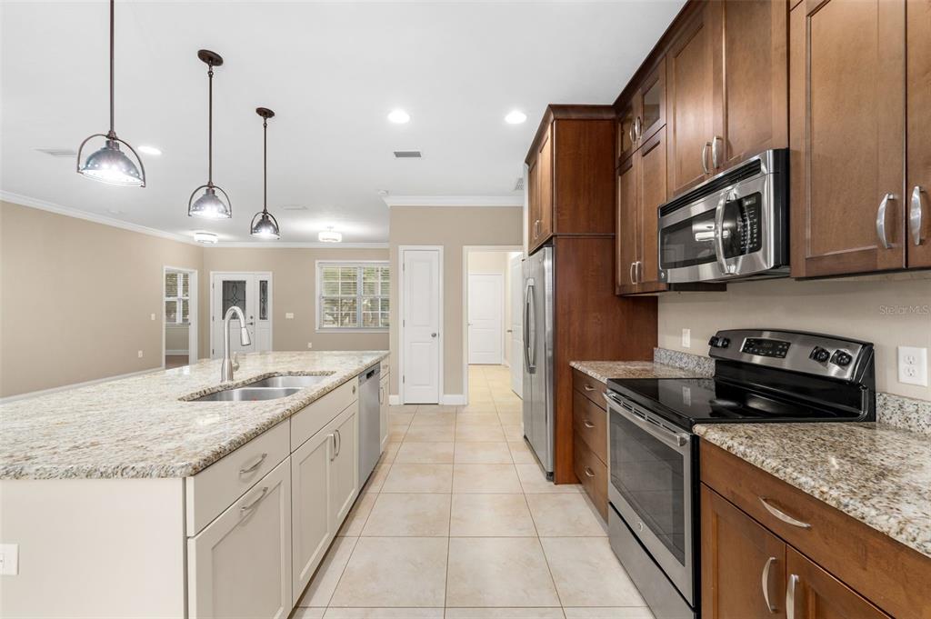 16617 Northwest 194th Street High Springs, FL 32643 - Photo 11 of 32 a kitchen with stainless steel appliances granite countertop a sink a stove and a refrigerator