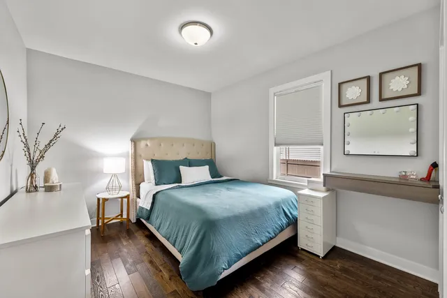 a bedroom with a bed wooden floor and windows