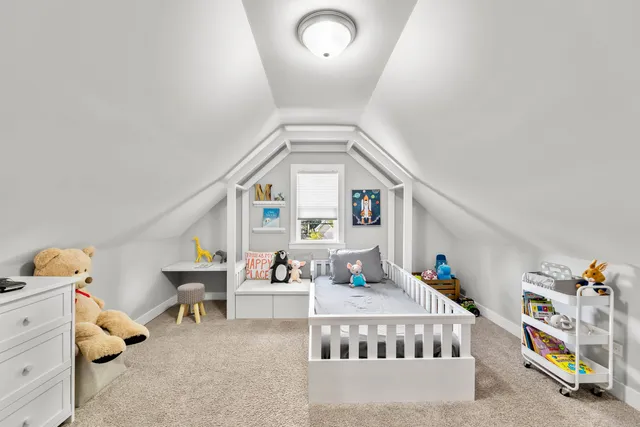 a living room with furniture and a baby crib