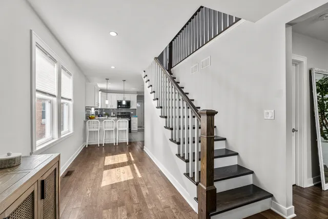 a view of entryway and kitchen with wooden floor