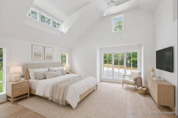 a bedroom with a bed and a flat tv screen on the dresser