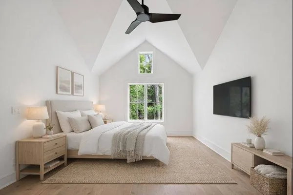 a bedroom with a bed a flat screen tv and a window