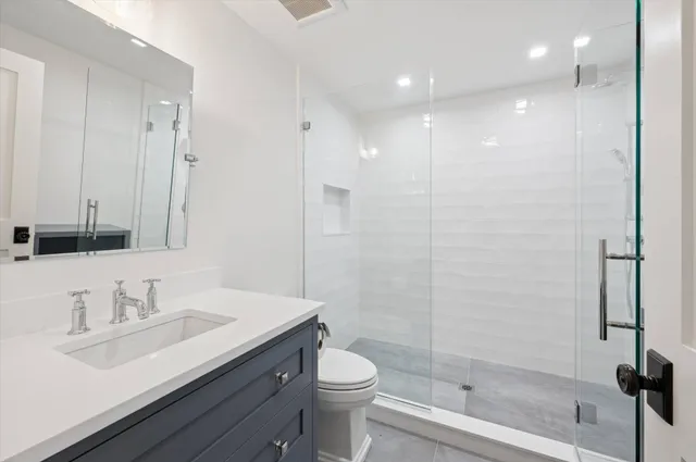 a bathroom with a sink a toilet and shower