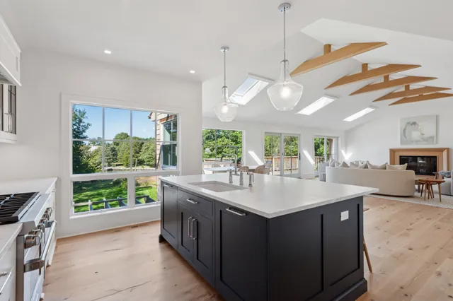 a kitchen with kitchen island granite countertop a sink a counter top space appliances and cabinets