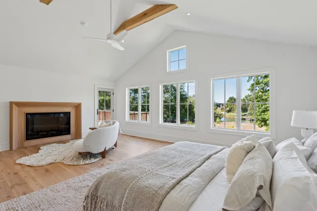 a bed sitting in a bedroom next to a window with a chandelier