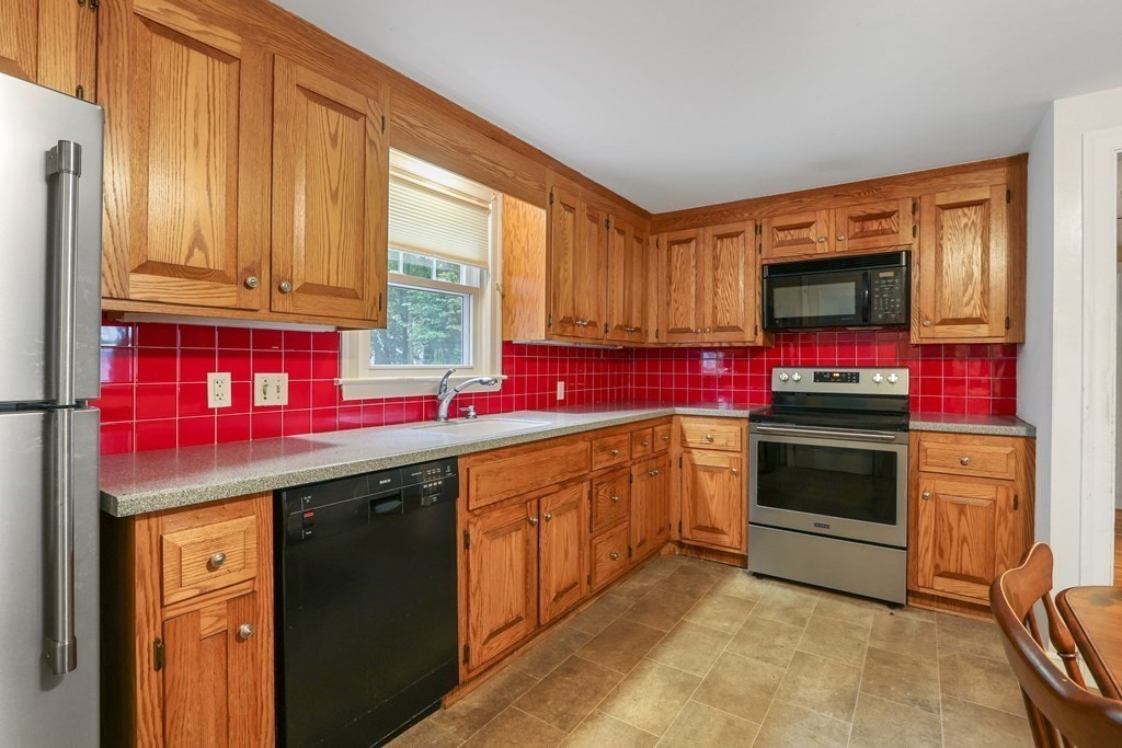 21 Cutler Drive Ashland, MA 01721 - Photo 11 of 34 a kitchen with stainless steel appliances a stove sink and cabinets